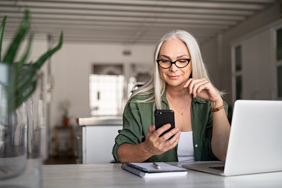 woman using her phone and smiling