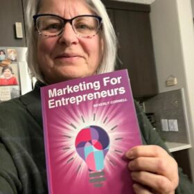 Francine Fox holding the Marketing For Entrepreneurs Book